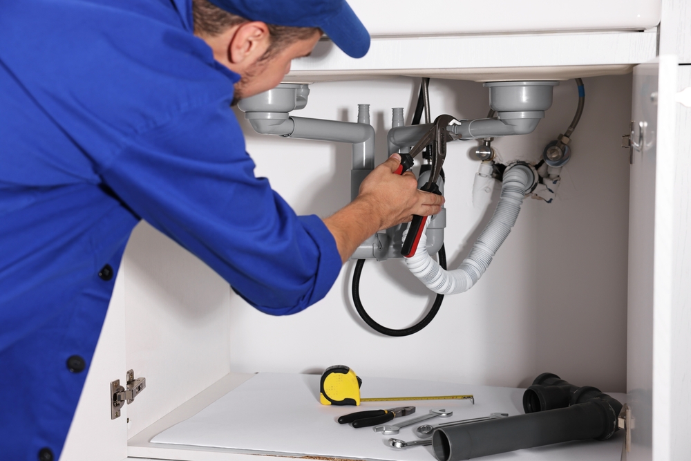 Professional,Plumber,Fixing,Piping,System,At,Home Professional plumber fixing piping system at home