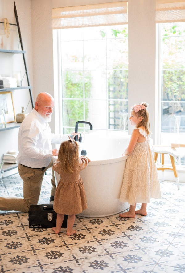 plumber inspecting freestanding bathtub faucet