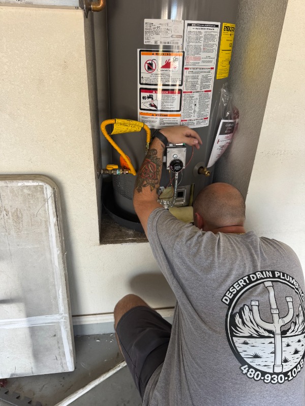 plumber servicing residential water heater unit