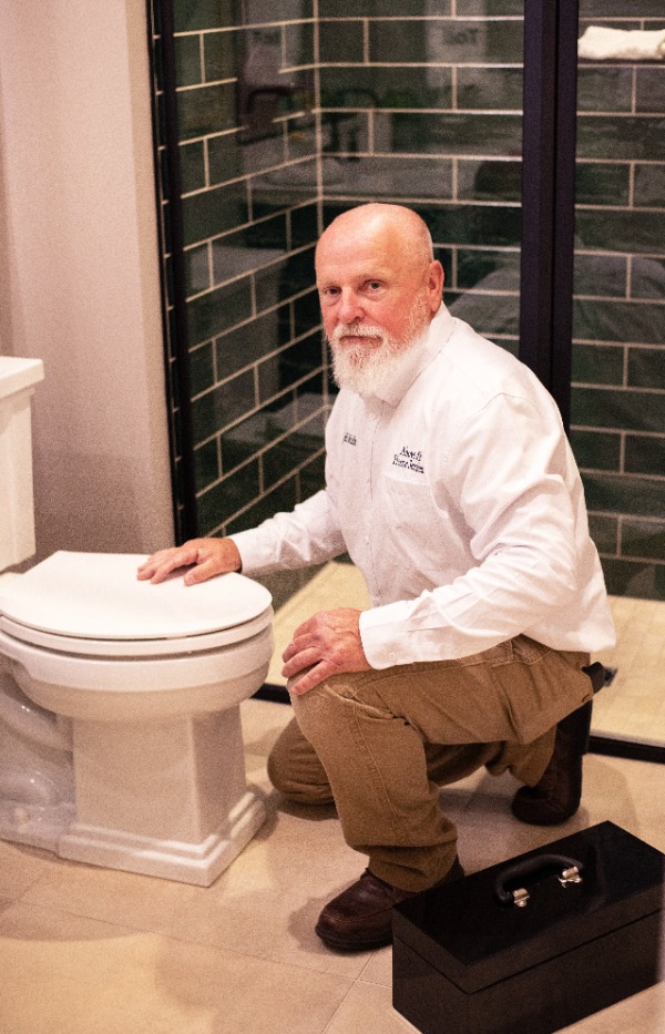 technician inspecting residential bathroom toilet